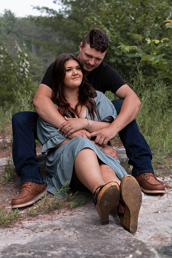 Fiancé wraps his arm around his soon to be wife during an engagement shoot