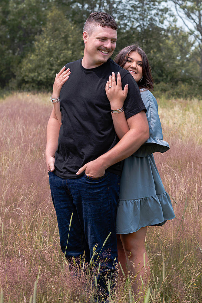 Couple embraces in a field during their couple shoot