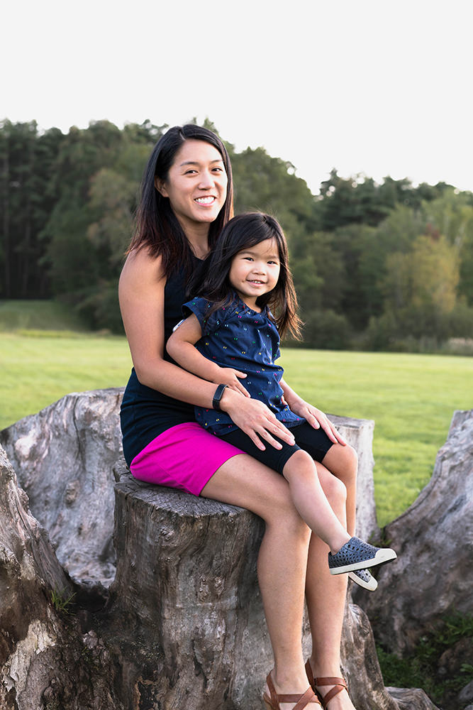 Little girl sits on her moms lap during a family photo shoot