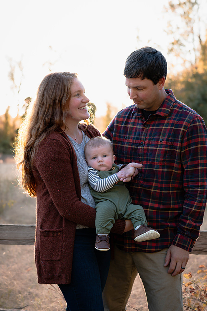 Mother and father hold baby together during family photoshoot