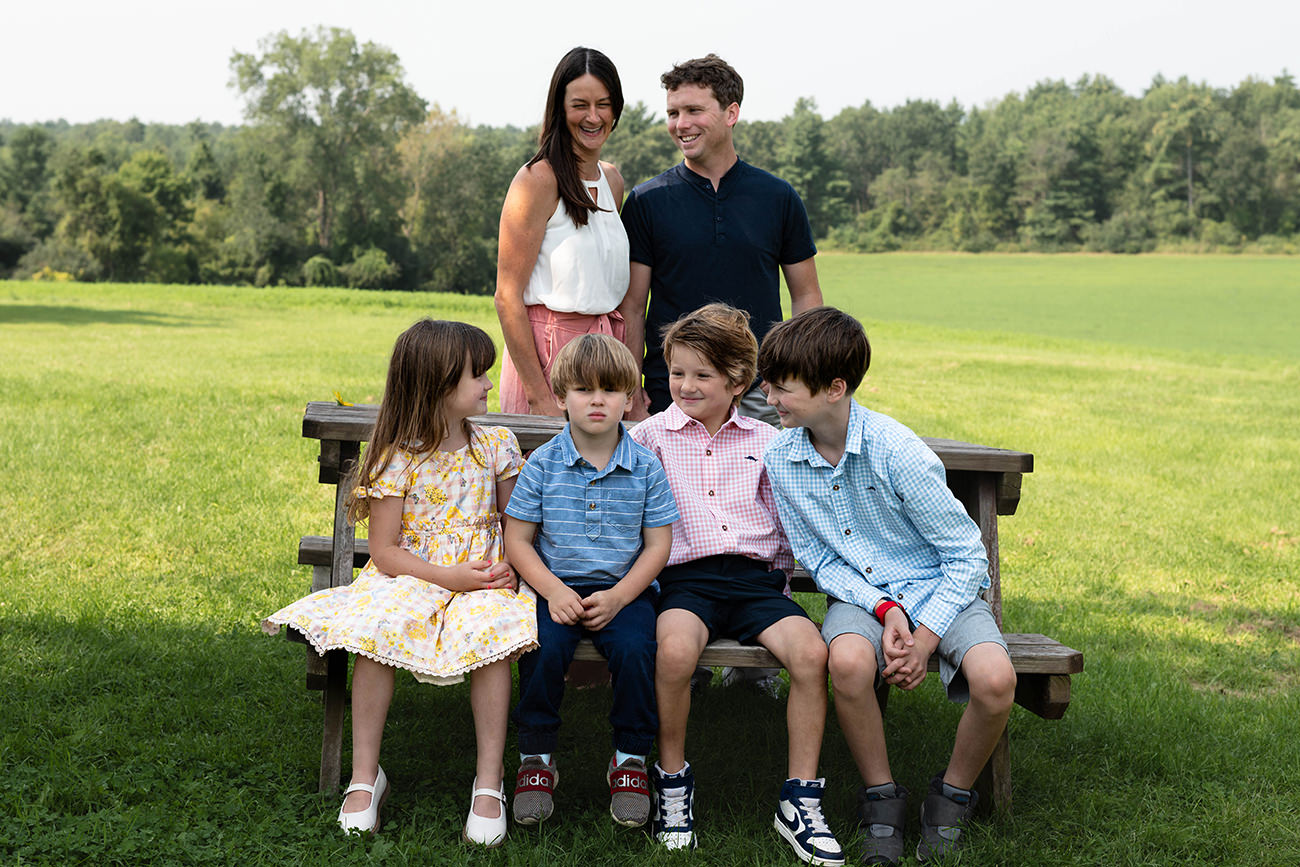 Family gather around a picnic table during photoshoot