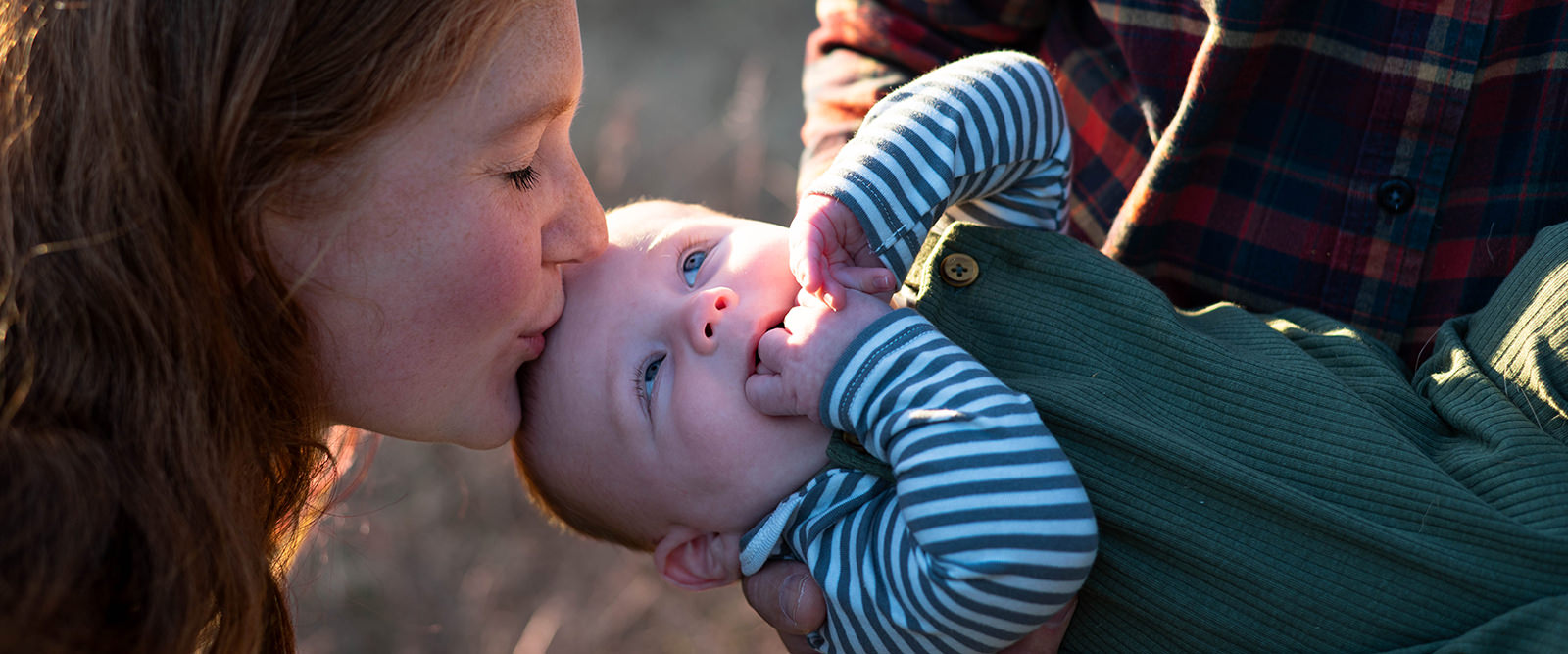 Woman kissing her child on the forehead