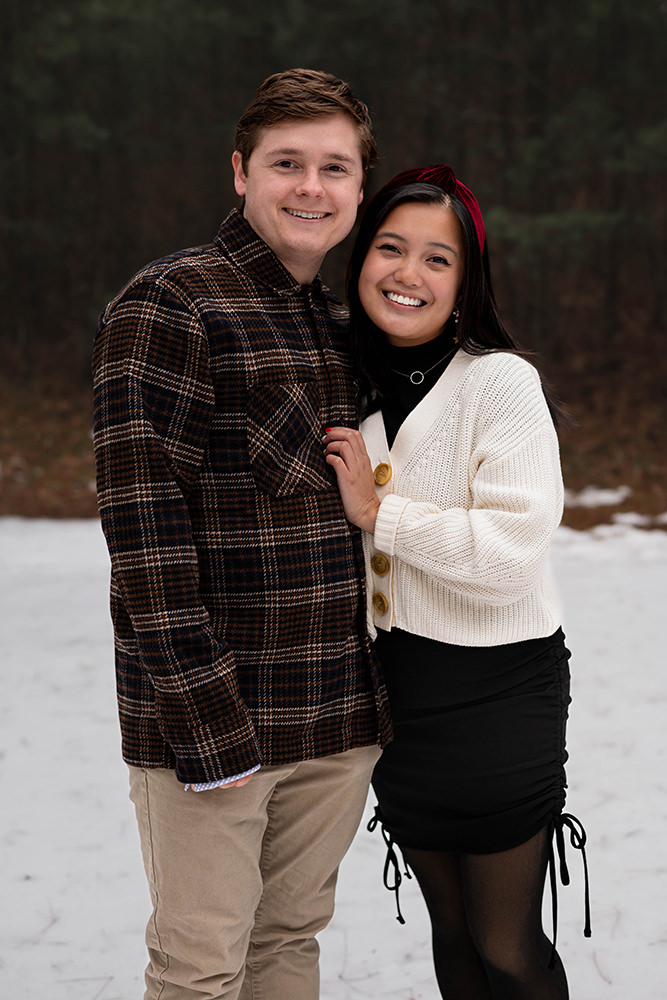 Couple poses for photo in snow during holiday shoot