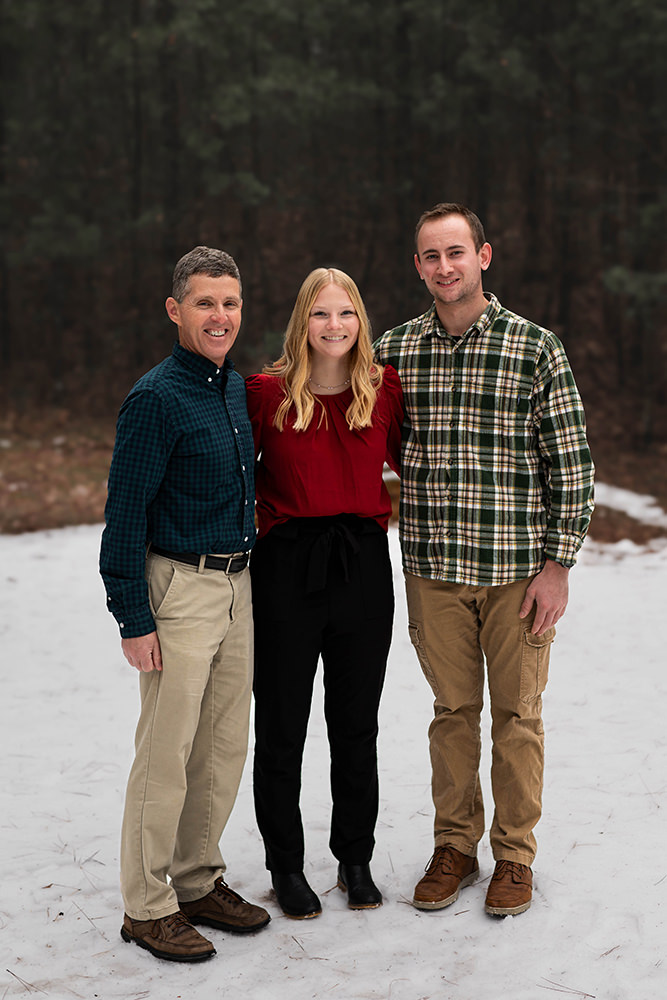 Family poses for a photo in the snow during the holidays