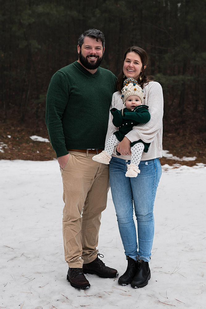 You couple poses for family photo with their baby