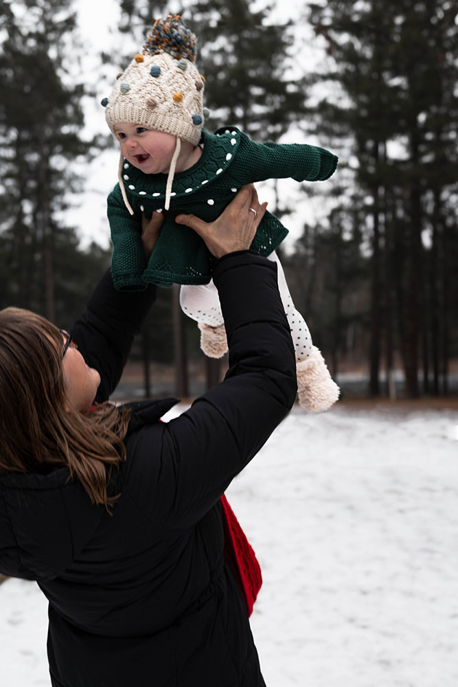 Grandma hoists her granddaughter up during family photo shoot