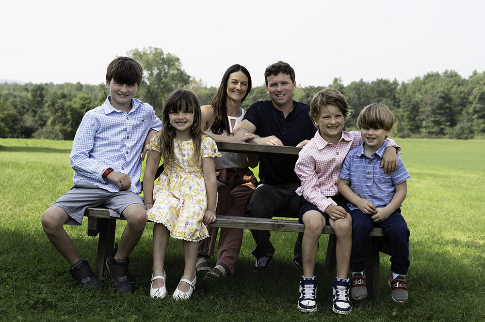 Family posing for a picture on a picnic table