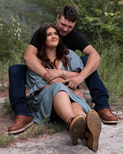 Fiancé wraps his arm around his soon to be wife during an engagement shoot