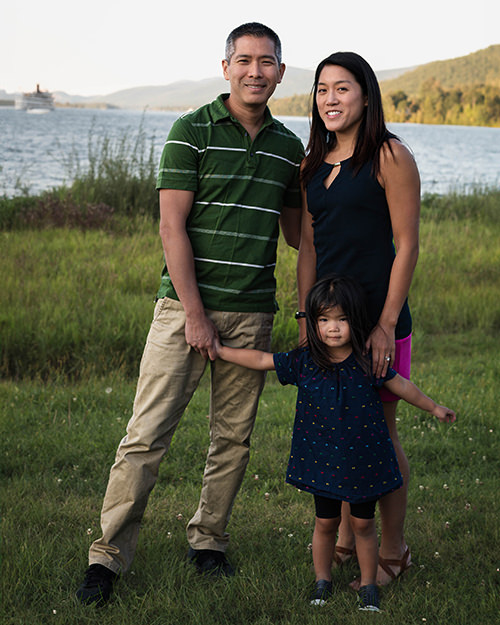 Family stands in front of lake during photoshoot